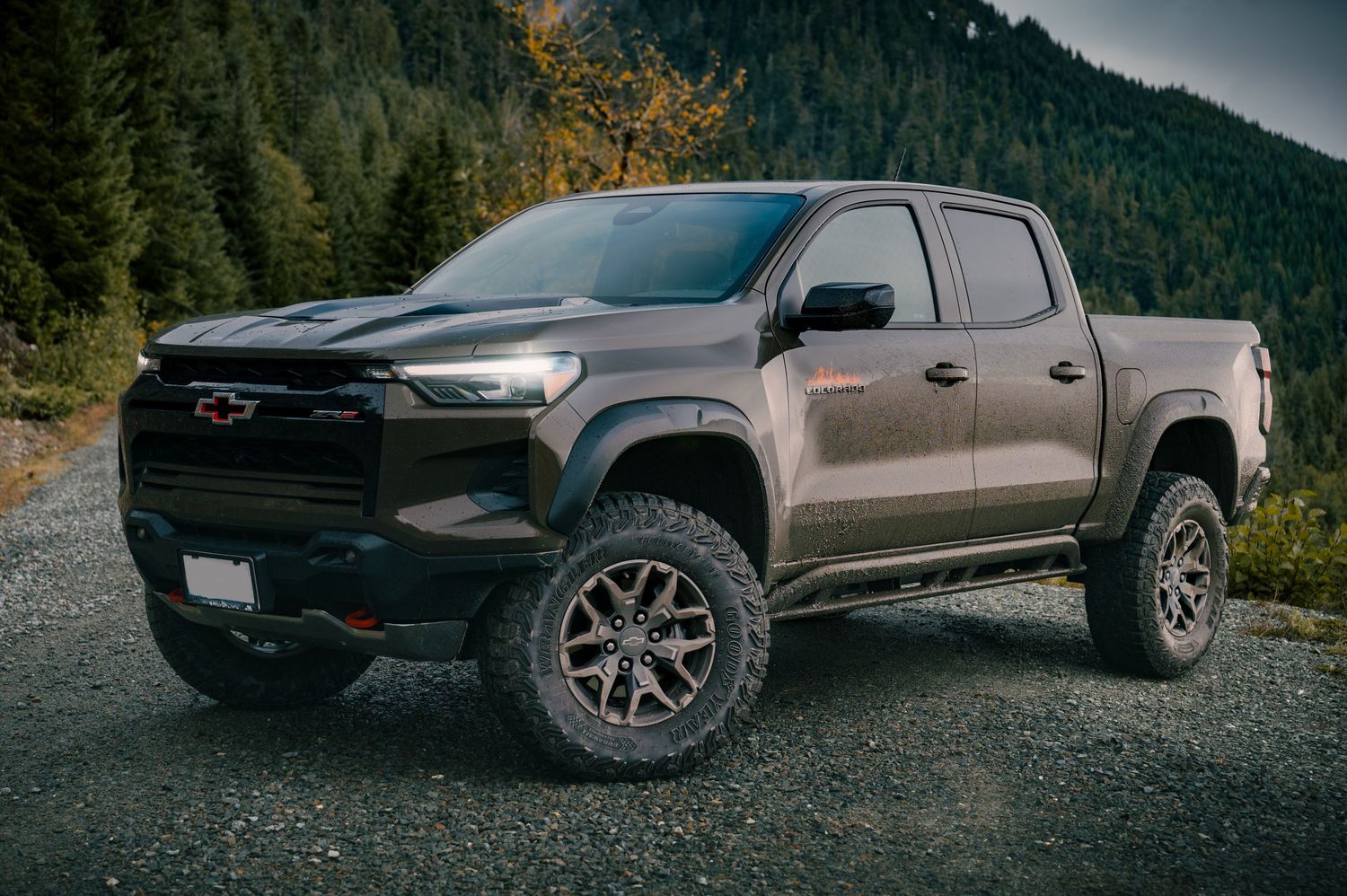 A Chevrolet Colorado pickup truck parked on gravel with Mount Baker as a backdrop.