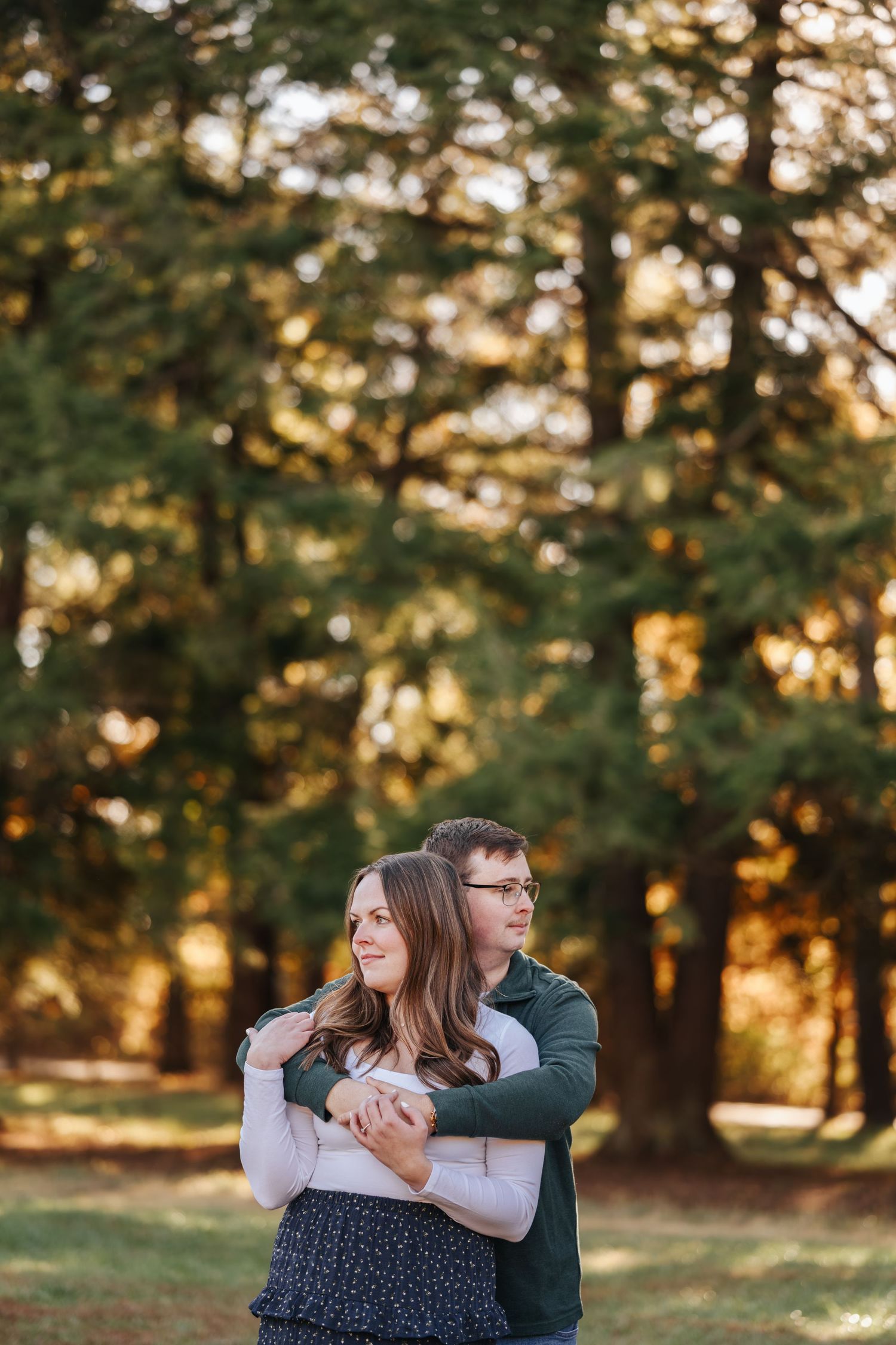 Intimate couple's portrait session among pine trees at sunset.