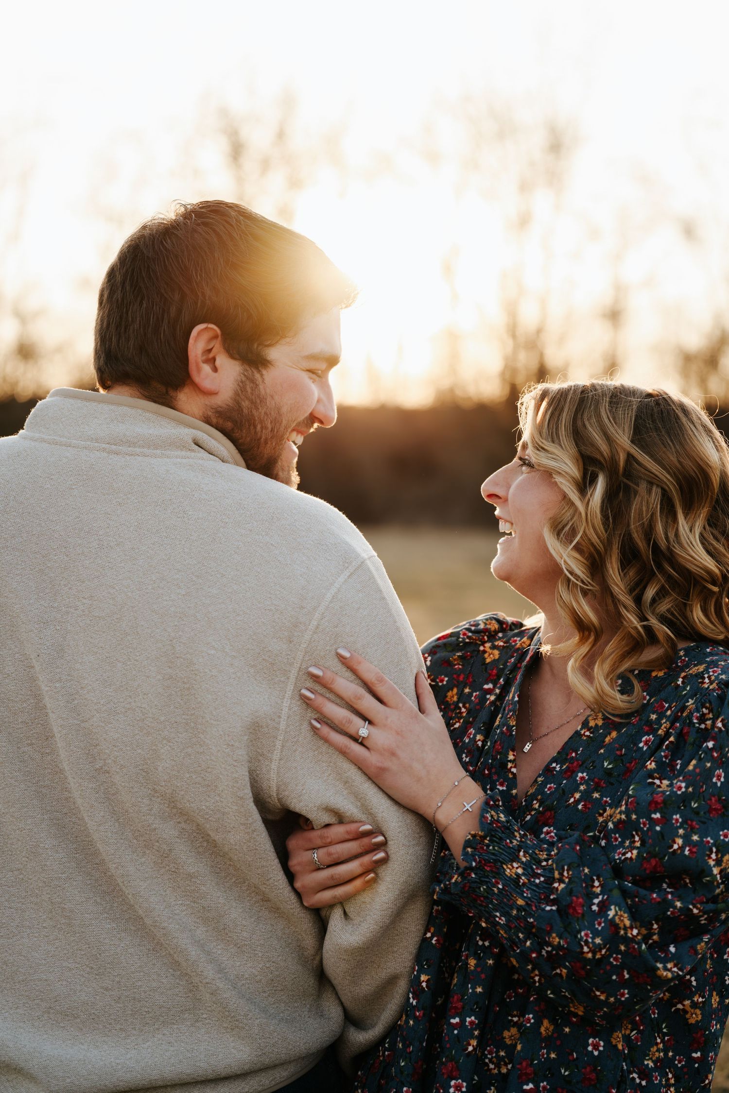 Couple embraces and laughs together during sunset portrait session.