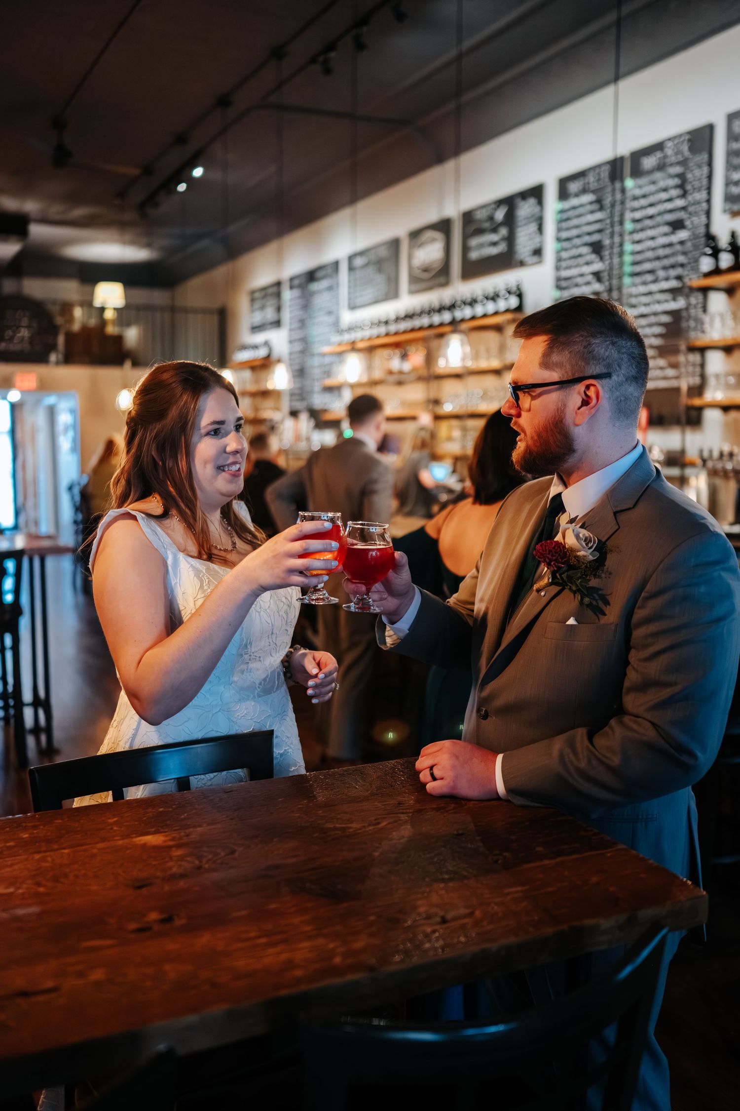 Couple enjoying drinks together at a rustic bar counter.