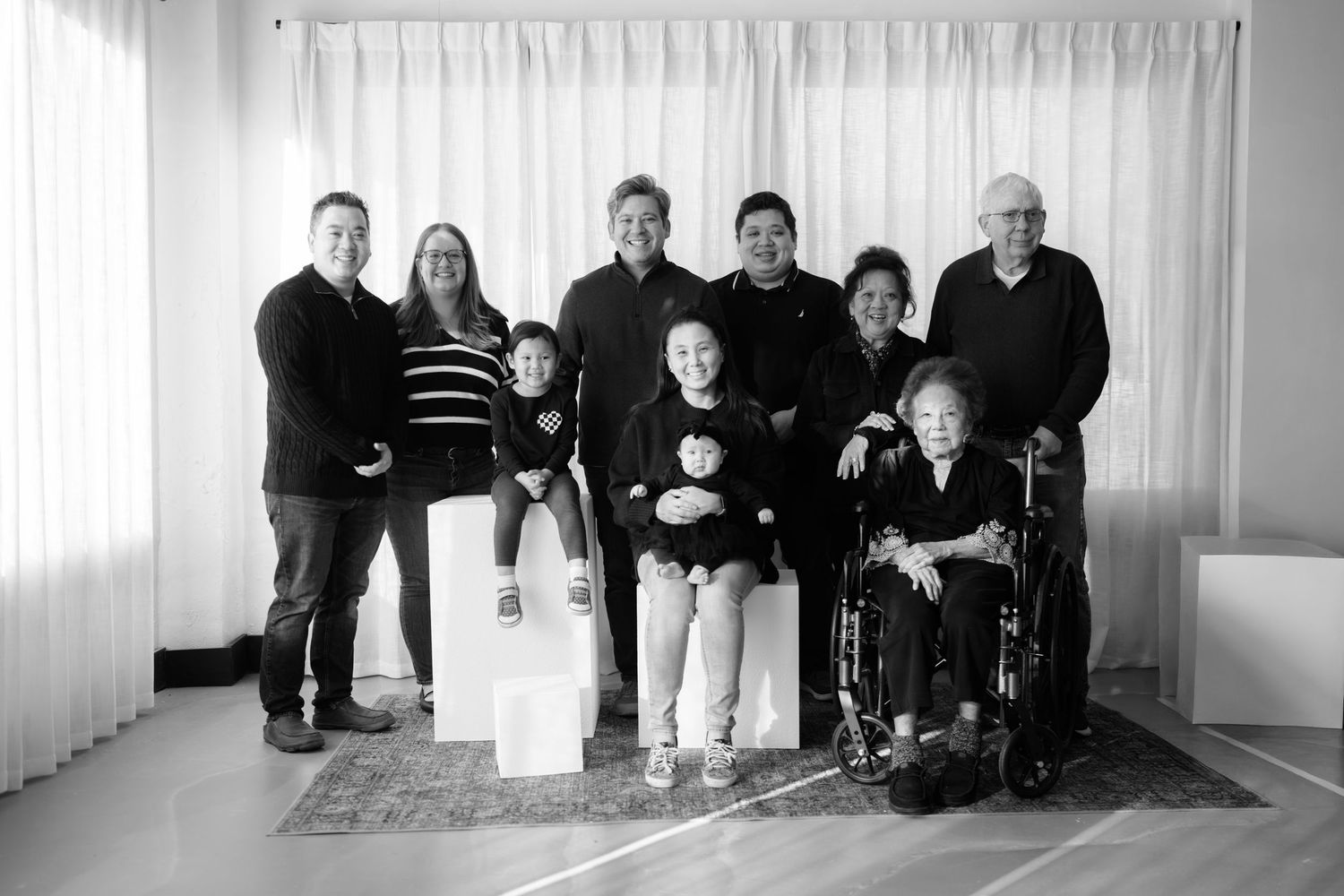 Panoramic family portrait in white room with Christmas decorations.