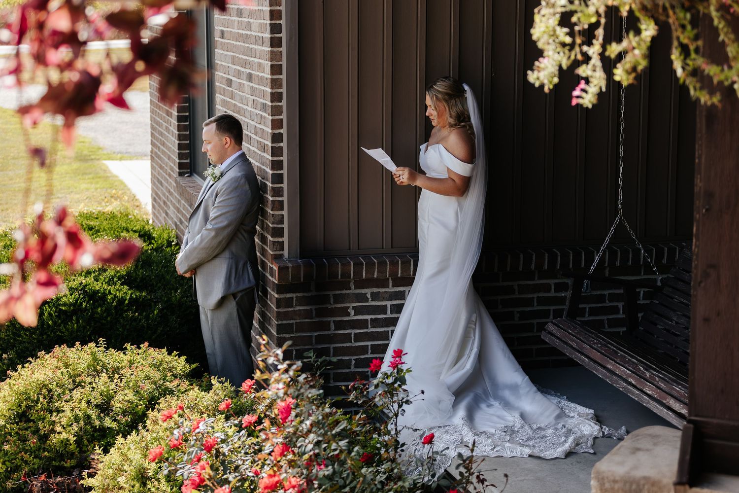 Romantic wedding couple portraits captured in an outdoor garden setting with brick architecture.