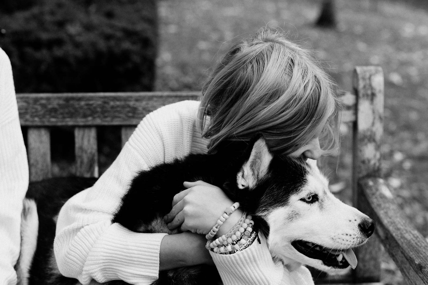A child and a husky enjoying a moment together in black and white photography.