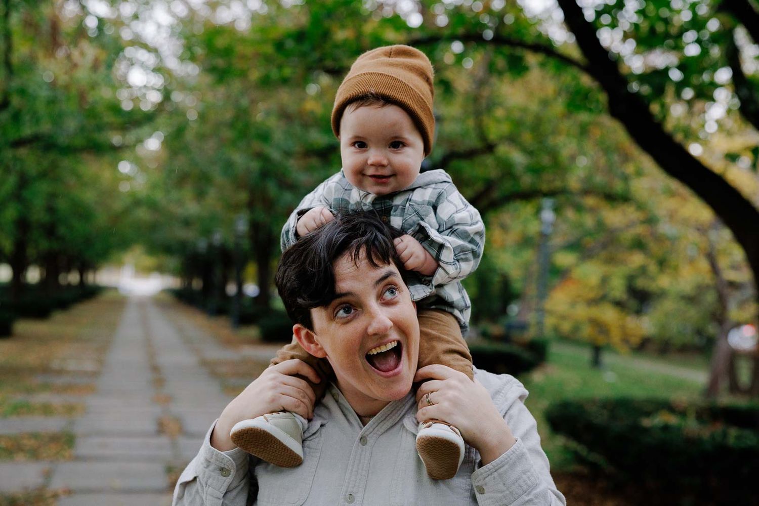 A joyful moment captured on a tree-lined path during autumn.