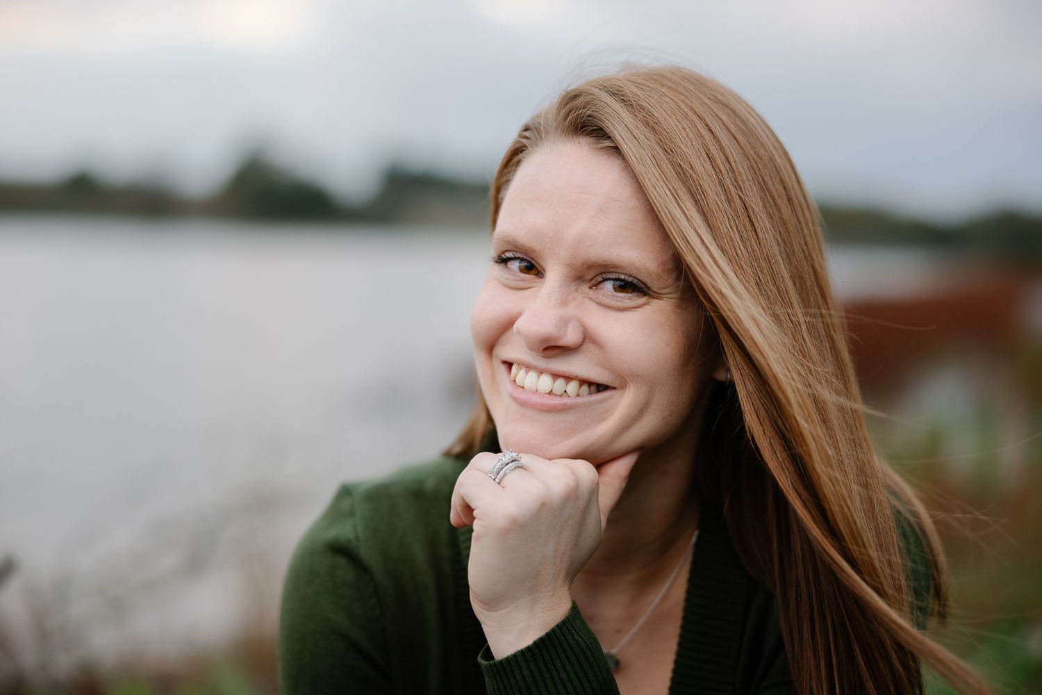 Lakeside portrait with soft evening light and water in background.
