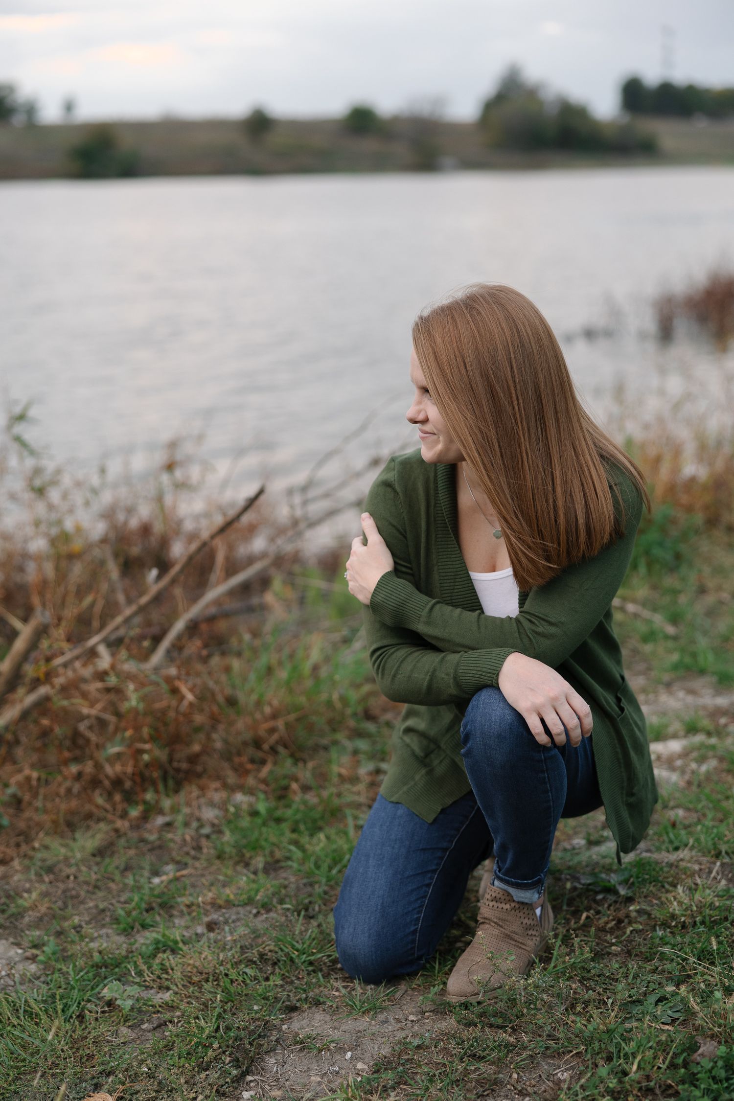 Casual outdoor portrait by the water with natural scenery.
