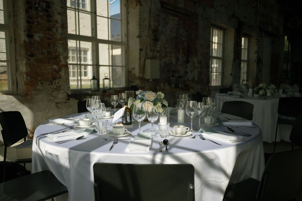 Rustic industrial dining space with exposed brick walls and elegant table settings.