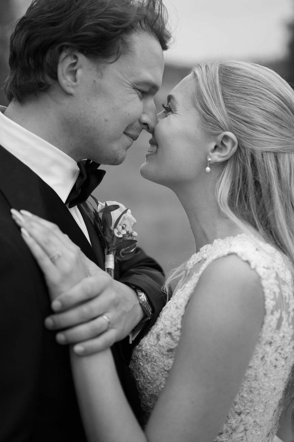 Black and white portrait of tender wedding moment outdoors.