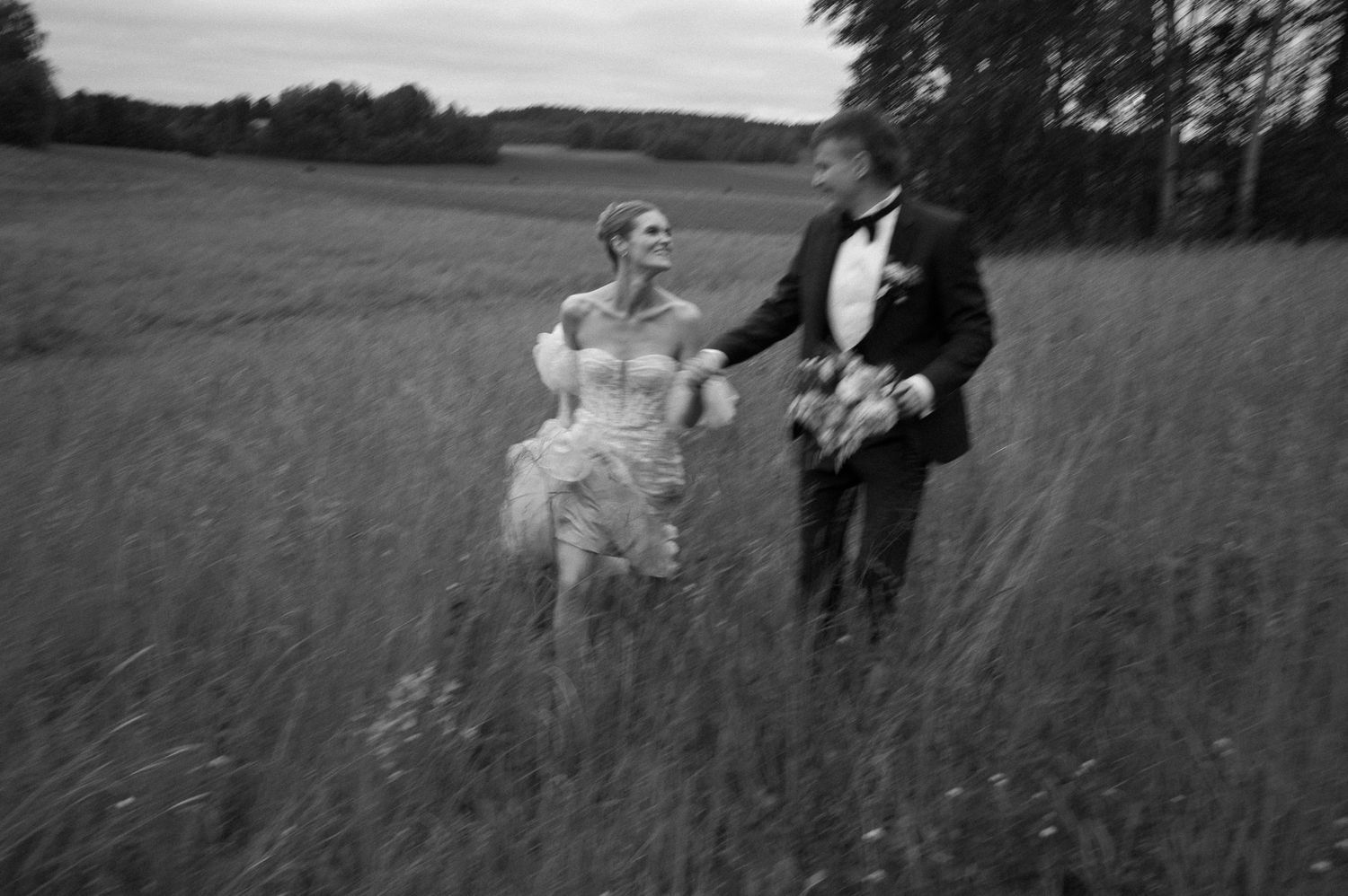 Black and white wedding photography in an open field landscape.