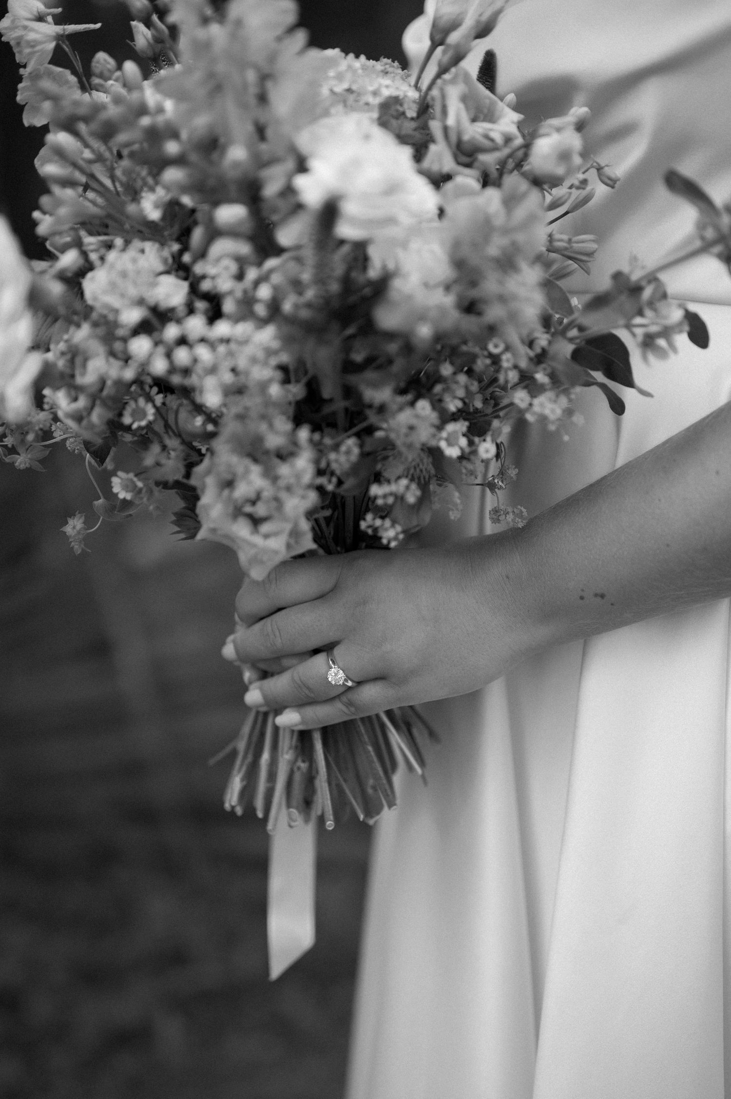 Elegant white floral bouquets with delicate blooms and ribbons displayed against a light background.