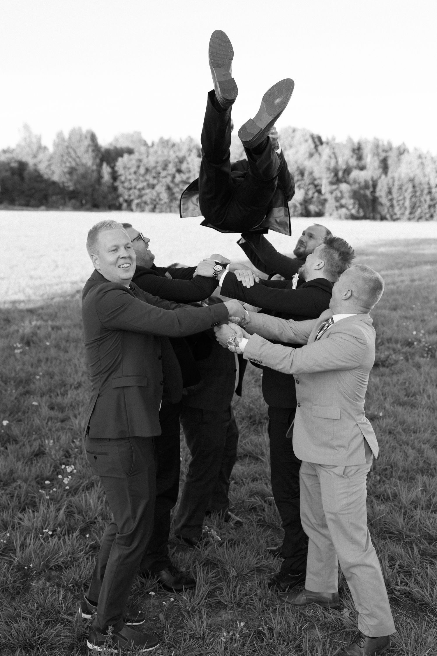 Staged wedding party fight scene captured in dramatic black and white photography.