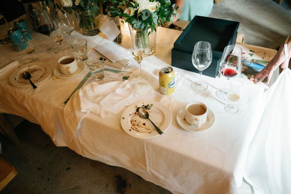 Long banquet tables set with white linens and floral arrangements for a wedding reception.