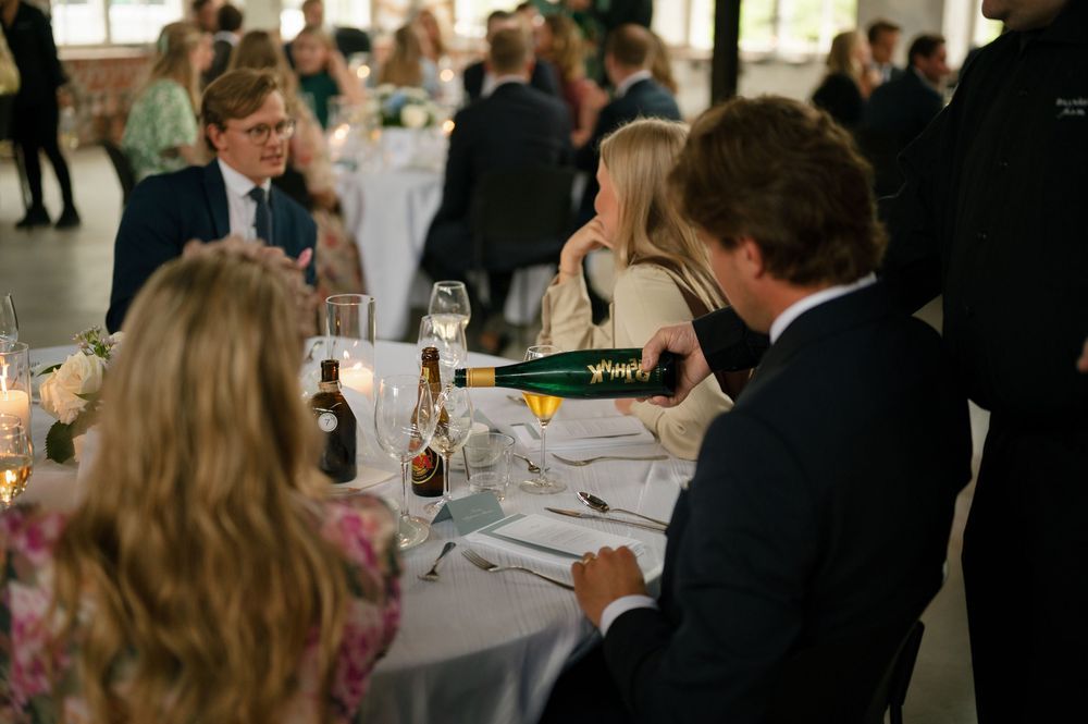Formal dining event with guests seated at white-clothed tables in a spacious room.