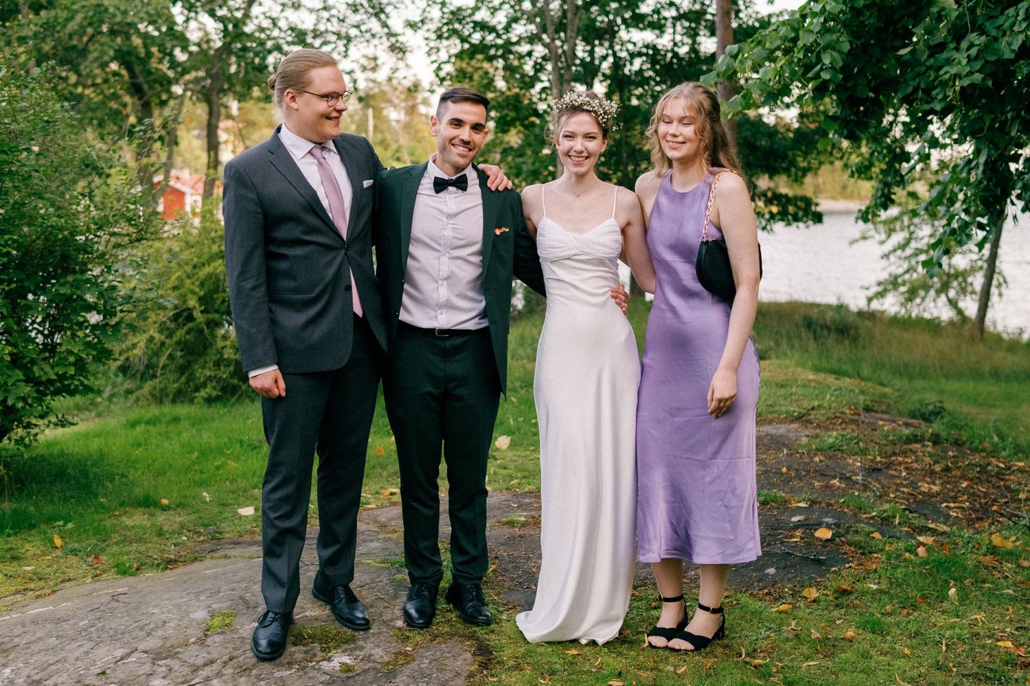 Wedding party poses together outdoors on a garden path during autumn.