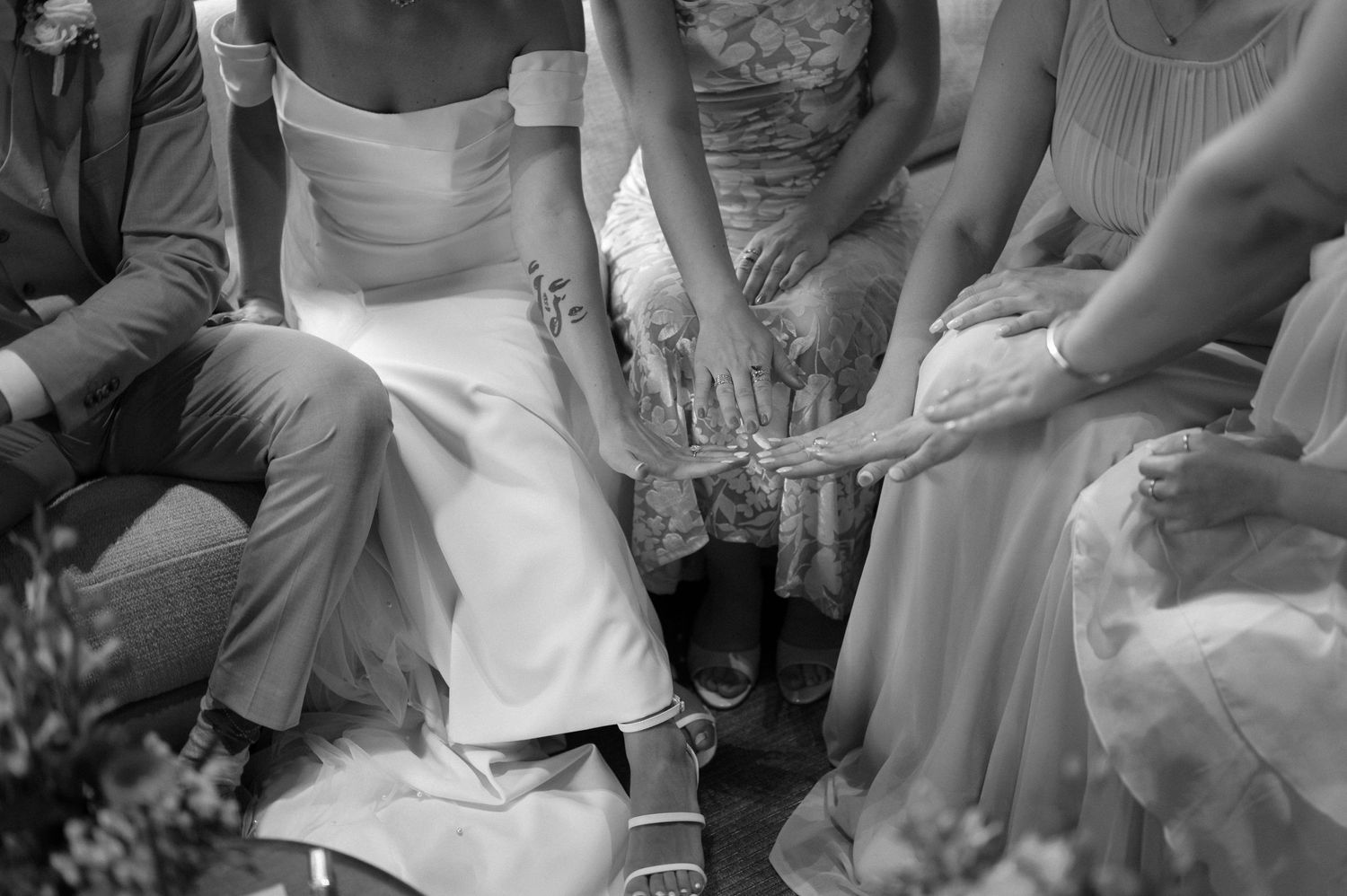 Wedding party members in formal attire seated together during celebration.