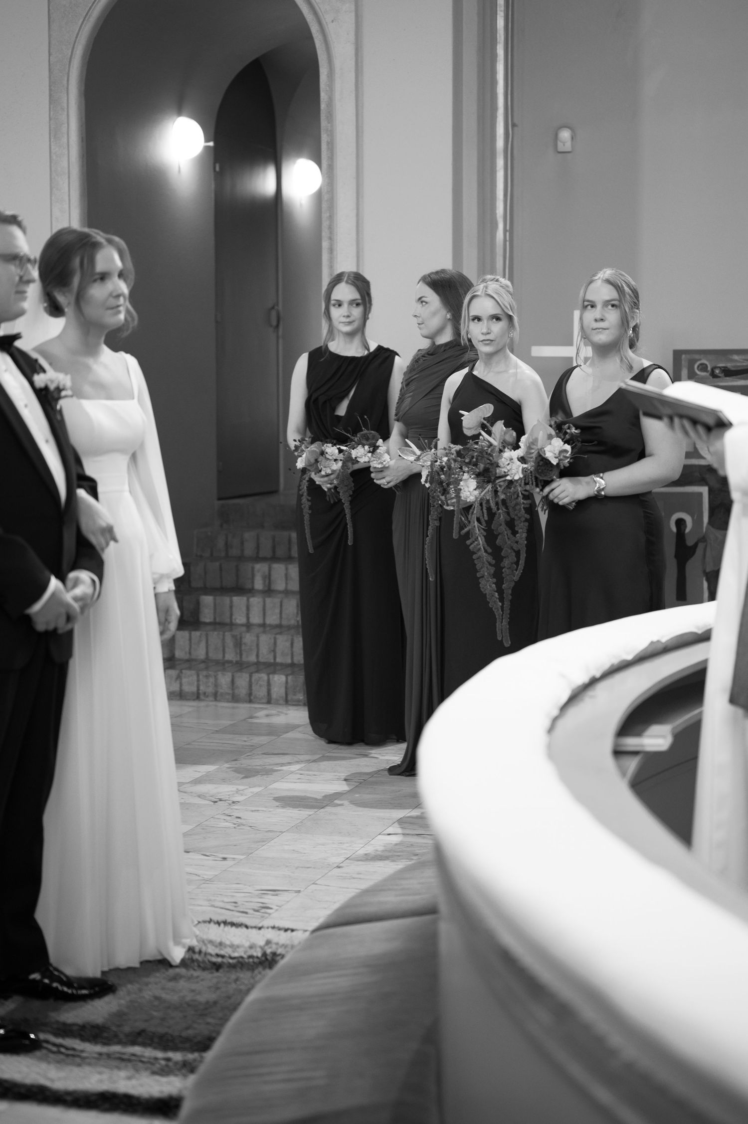 Black and white wedding photos show bridal party in elegant dresses standing in church interior during ceremony.