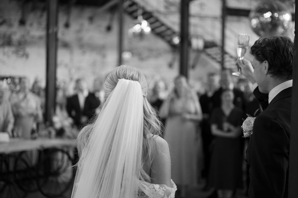 Black and white photo showing a wedding celebration in a formal indoor setting.