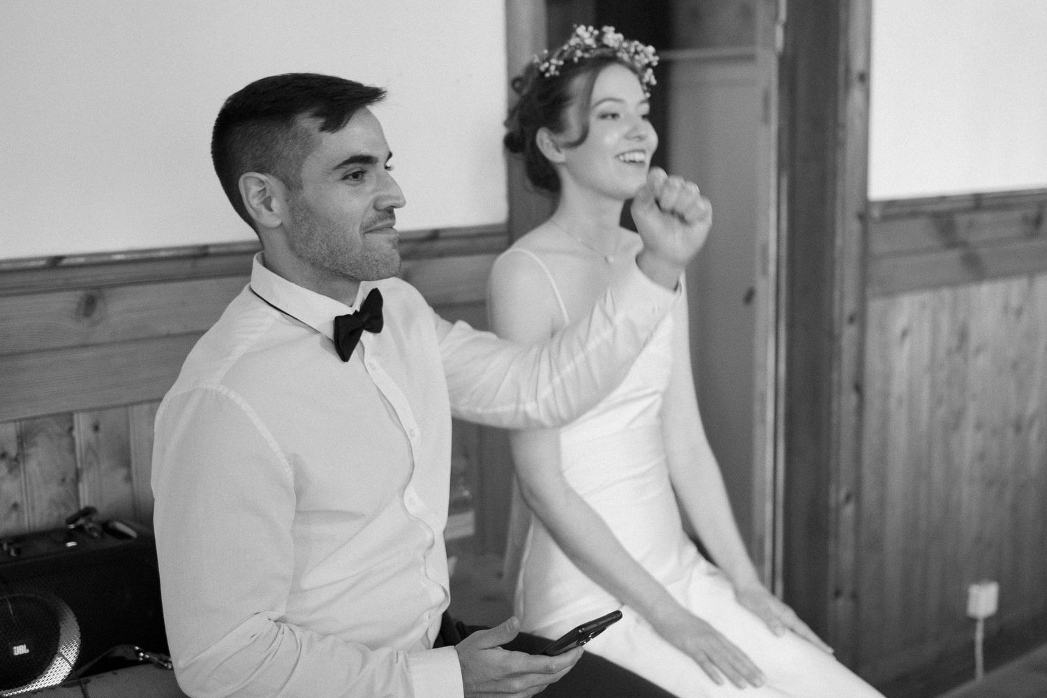 Elegant black and white photo of wedding celebration moments in a rustic venue.