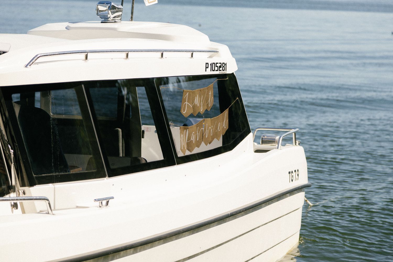 Close-up view of a white boat's cabin window on calm waters.