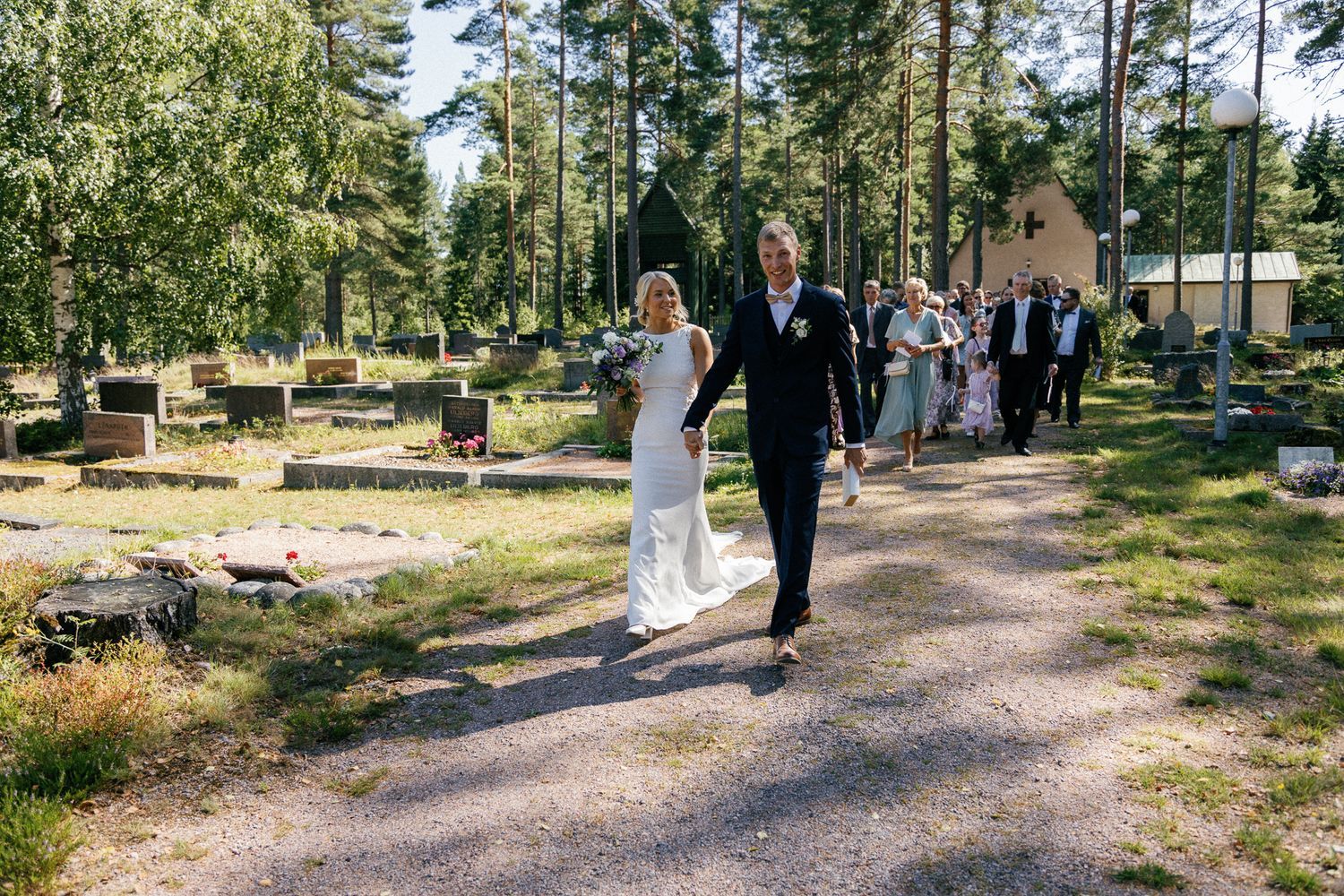 Wedding party walks along a winding forest path after the ceremony.
