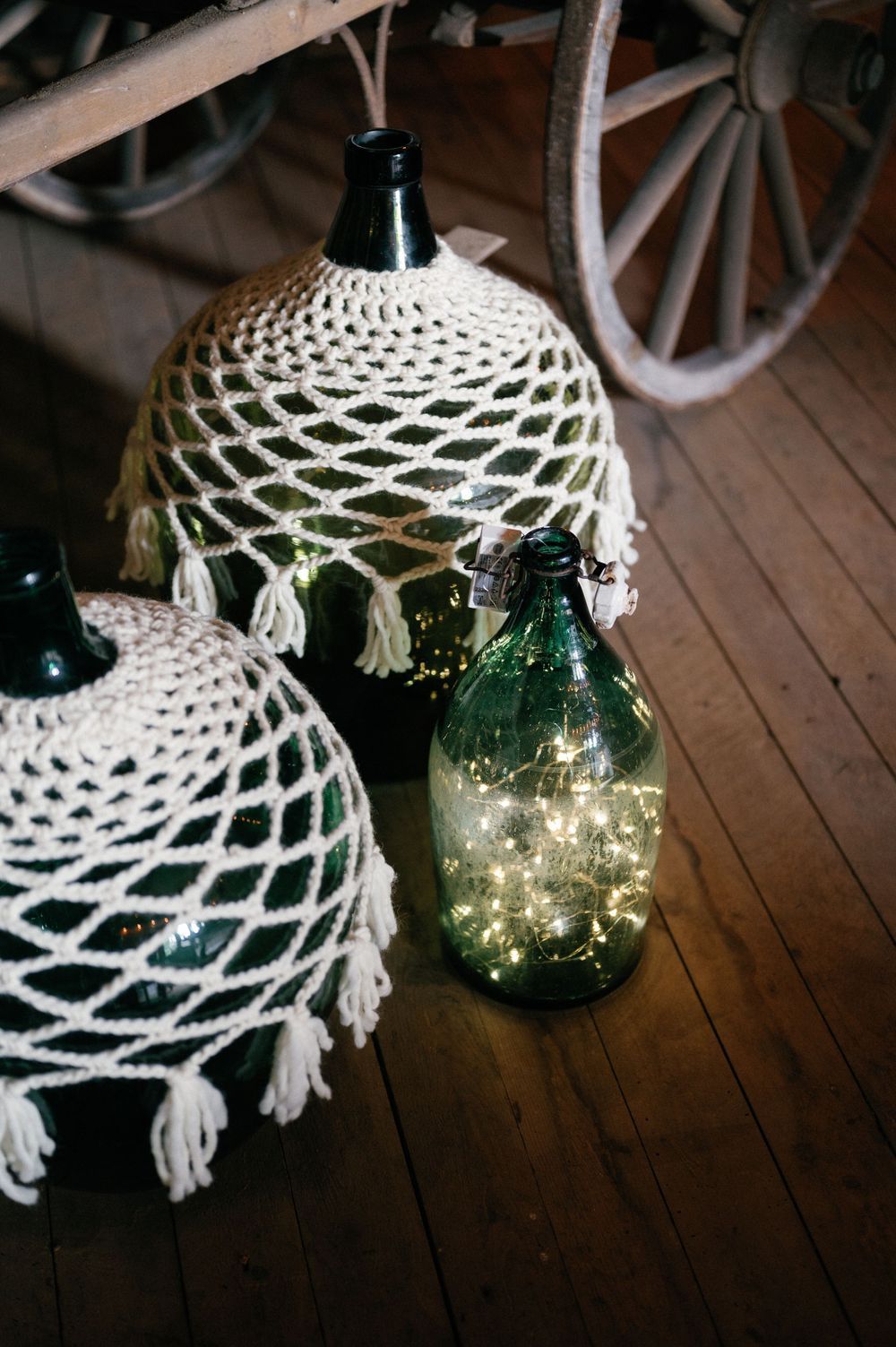 Decorative white crocheted lamp shades with fairy lights glowing through glass jars create an elegant vintage ambiance.
