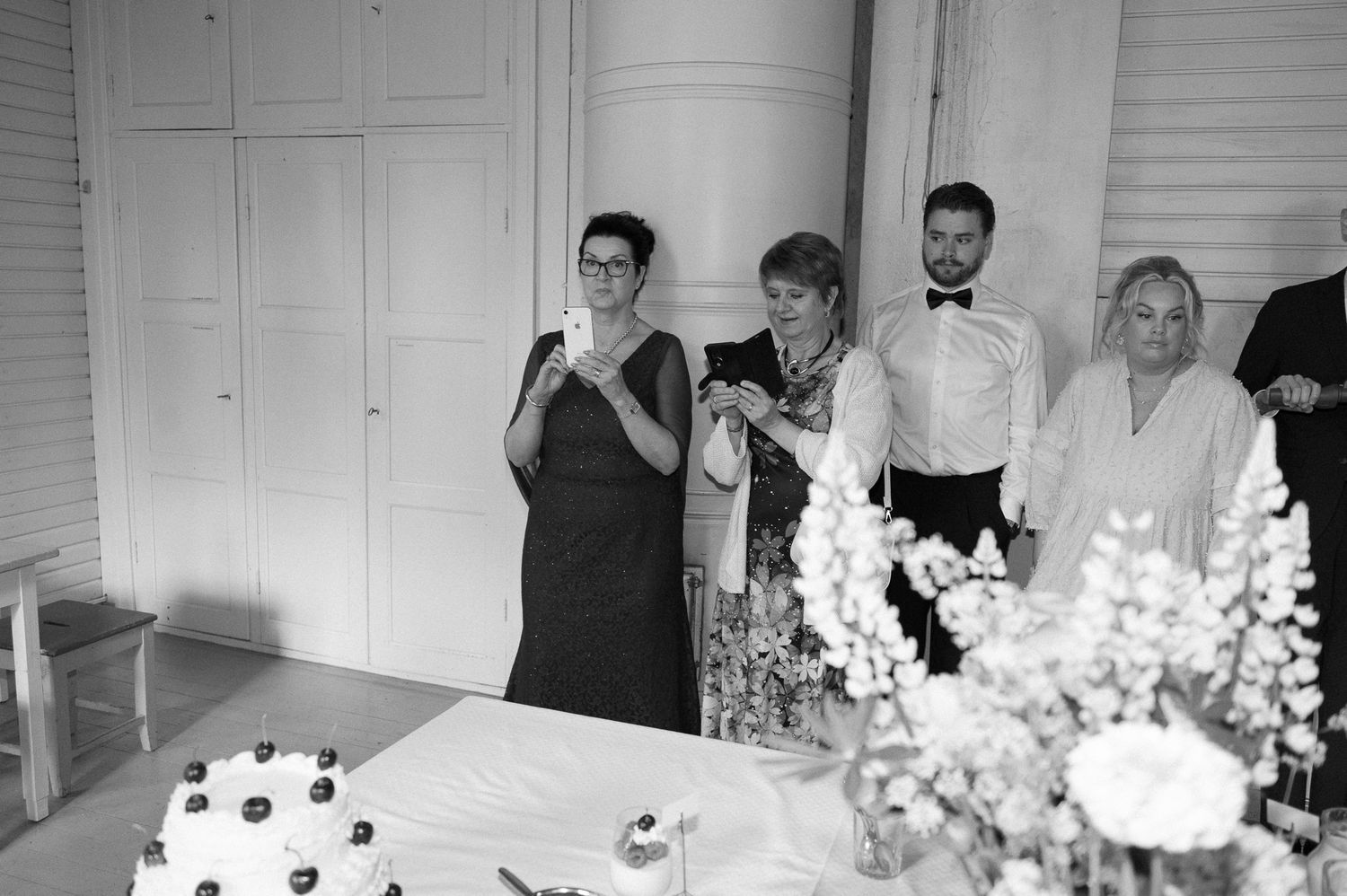 Wedding reception setup in a bright white room with floral decorations.