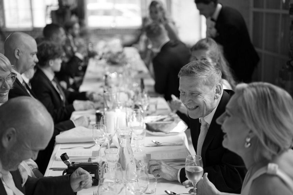 Formal dining event with guests seated at tables in historic brick building.