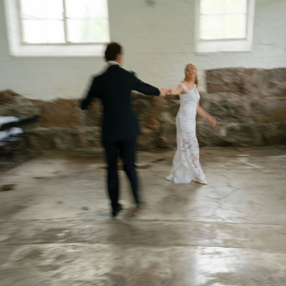 Motion-blurred sequence of a dancing couple in a bright industrial space.