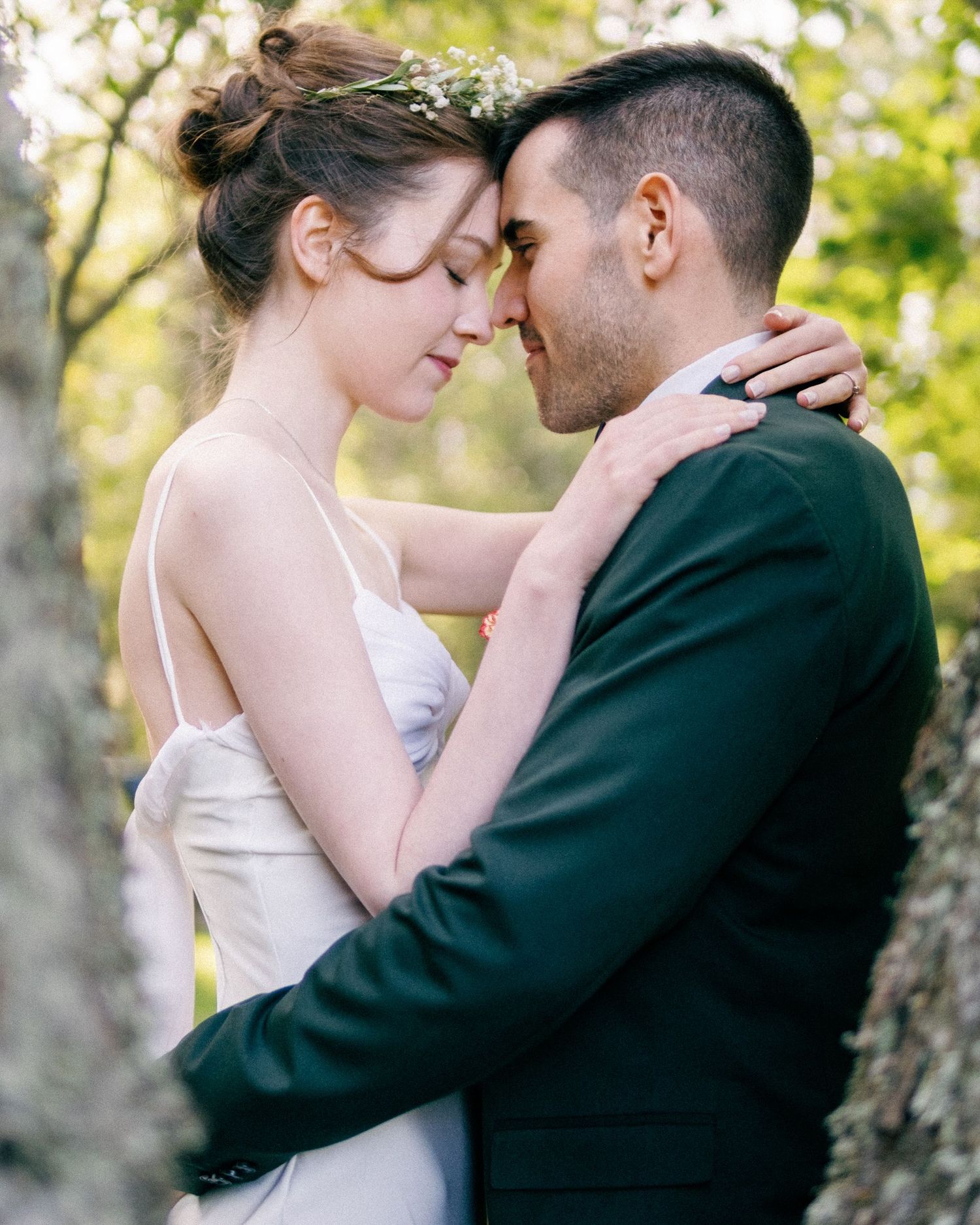 Romantic wedding portraits showing tender moments between couple in a garden setting.