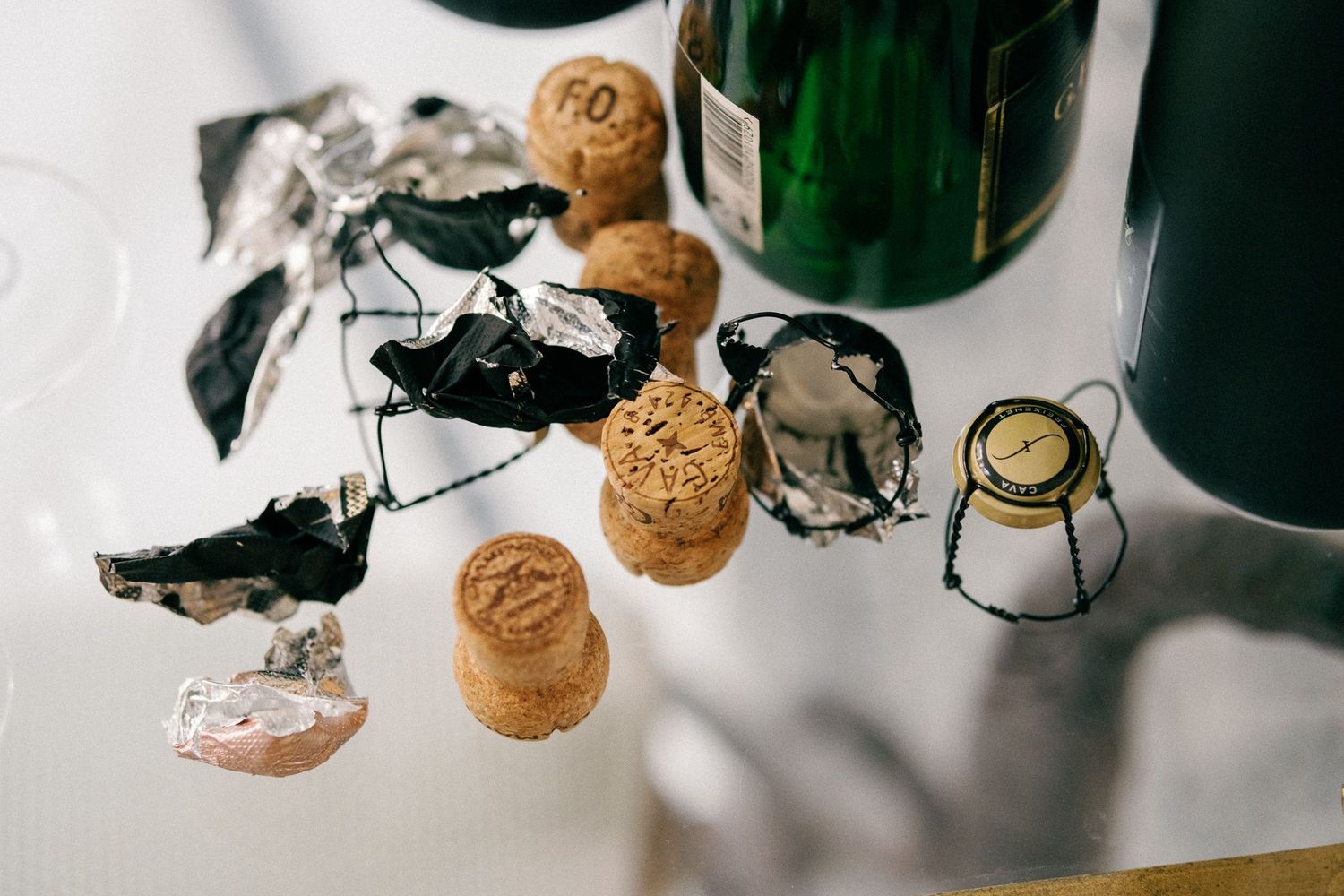 Close-up of champagne bottles and corks on a white surface.