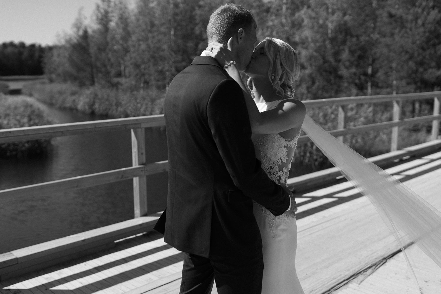 Black and white photo of a wooden deck with railings in natural setting.