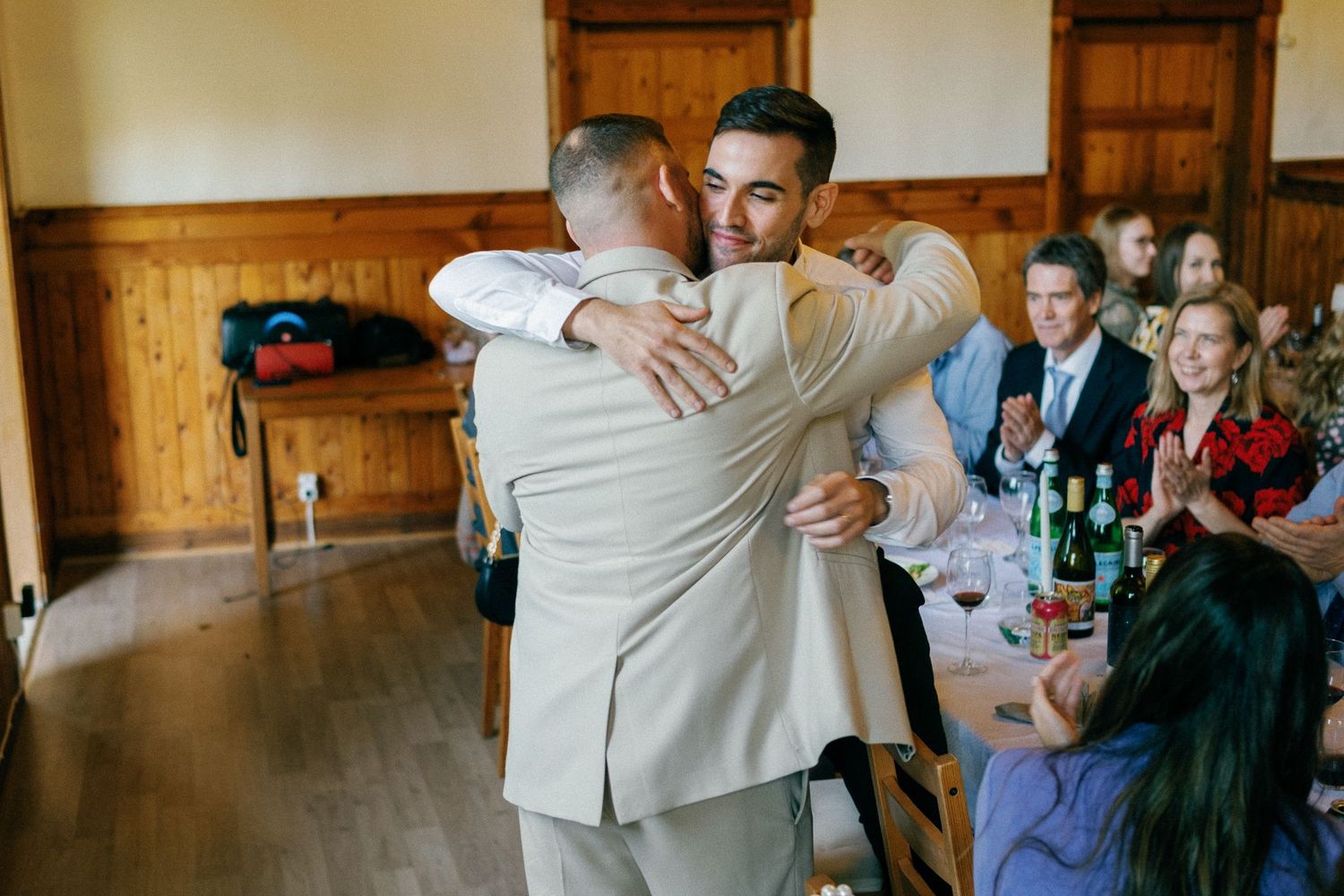Wedding party members embrace during an emotional moment at the reception.