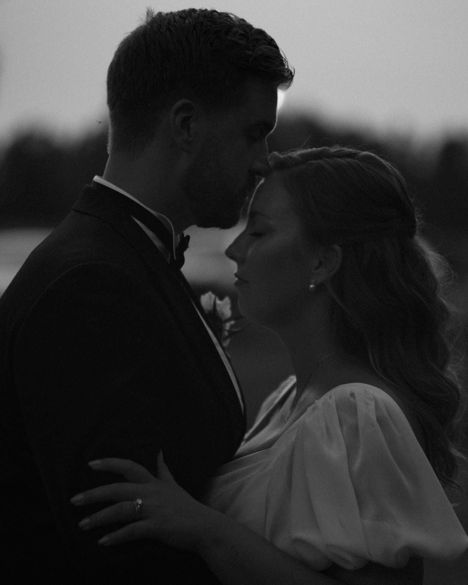 Black and white romantic silhouettes during an evening wedding celebration.