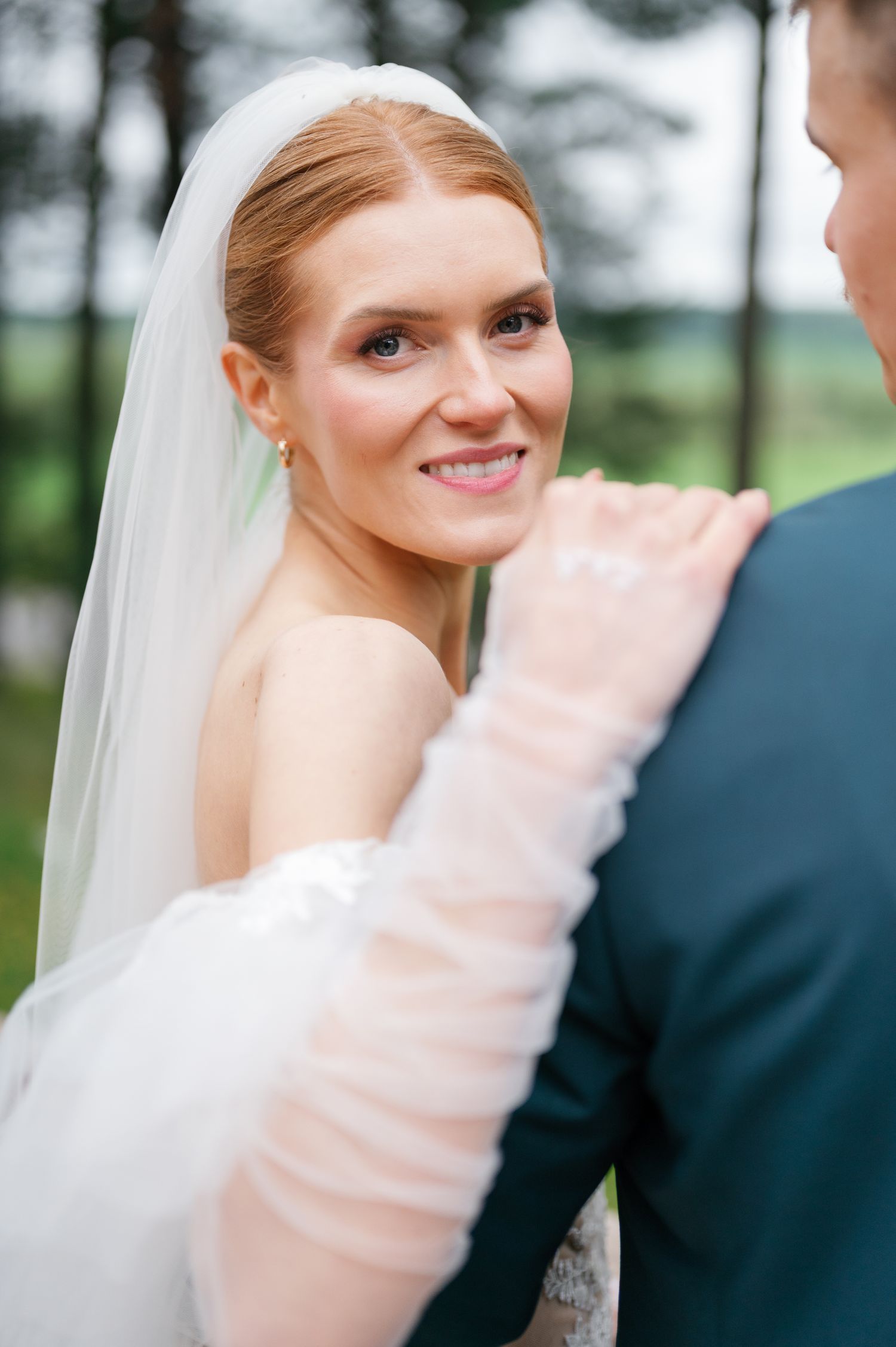 A tender moment between newlyweds in an outdoor garden setting.