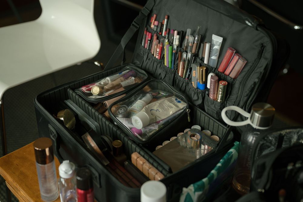 Professional makeup and styling equipment organized in black carrying cases.