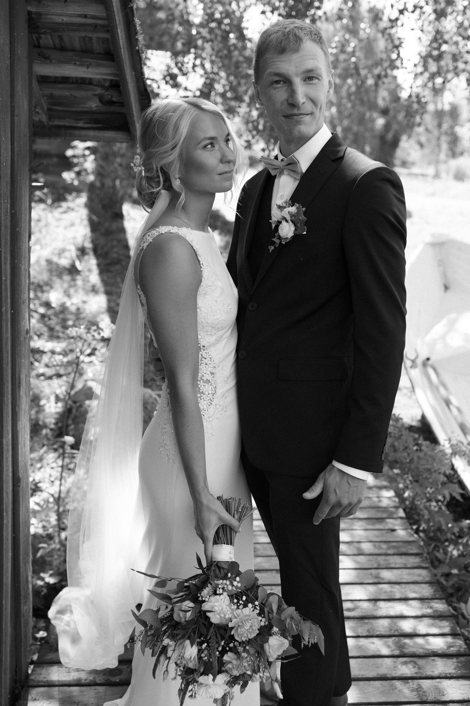 Romantic wedding couple poses together in black and white photography series against natural outdoor backdrop.
