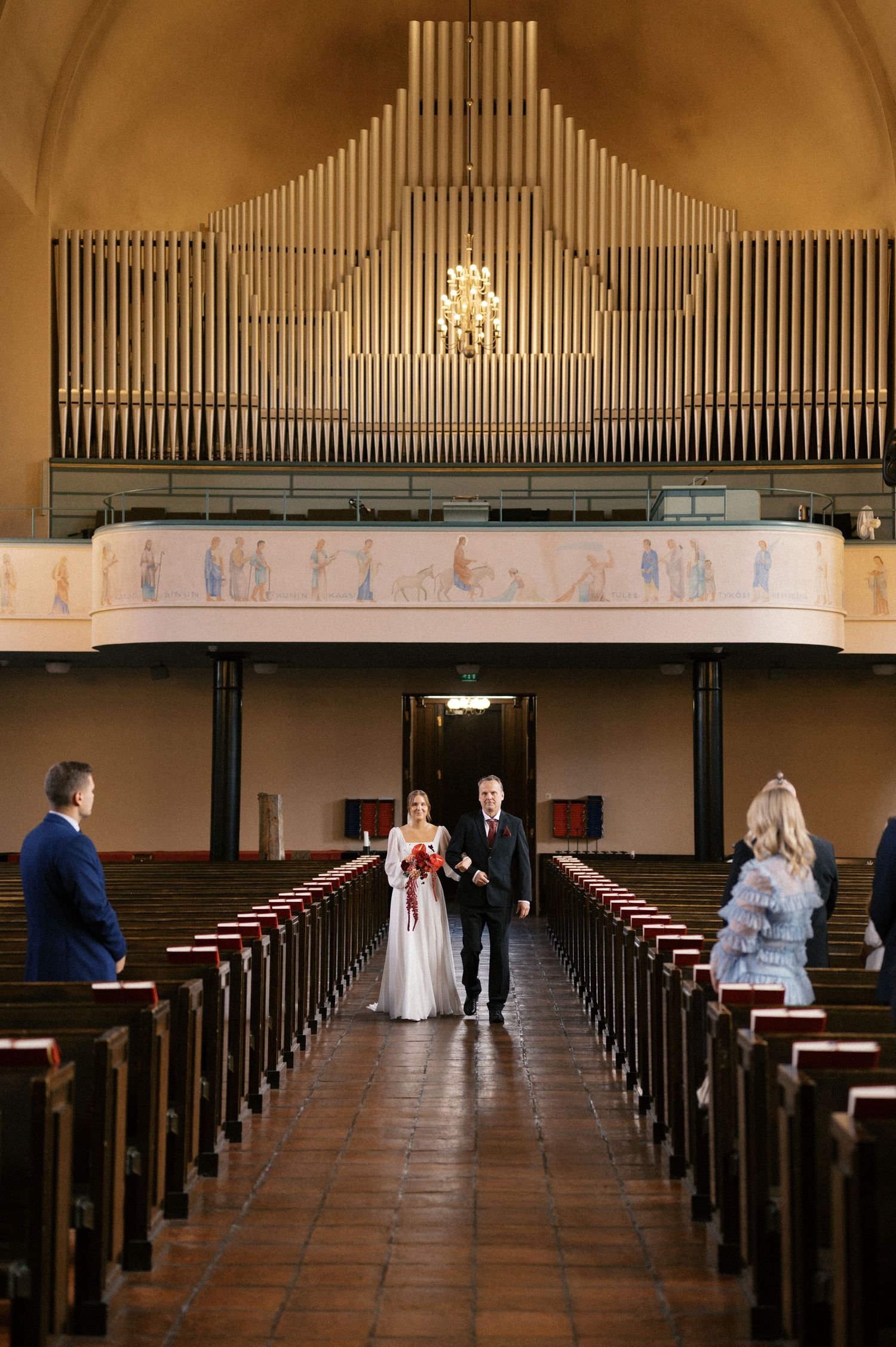 A series of four wedding photos showing a couple walking down a church aisle with wooden pews and organ pipes above.