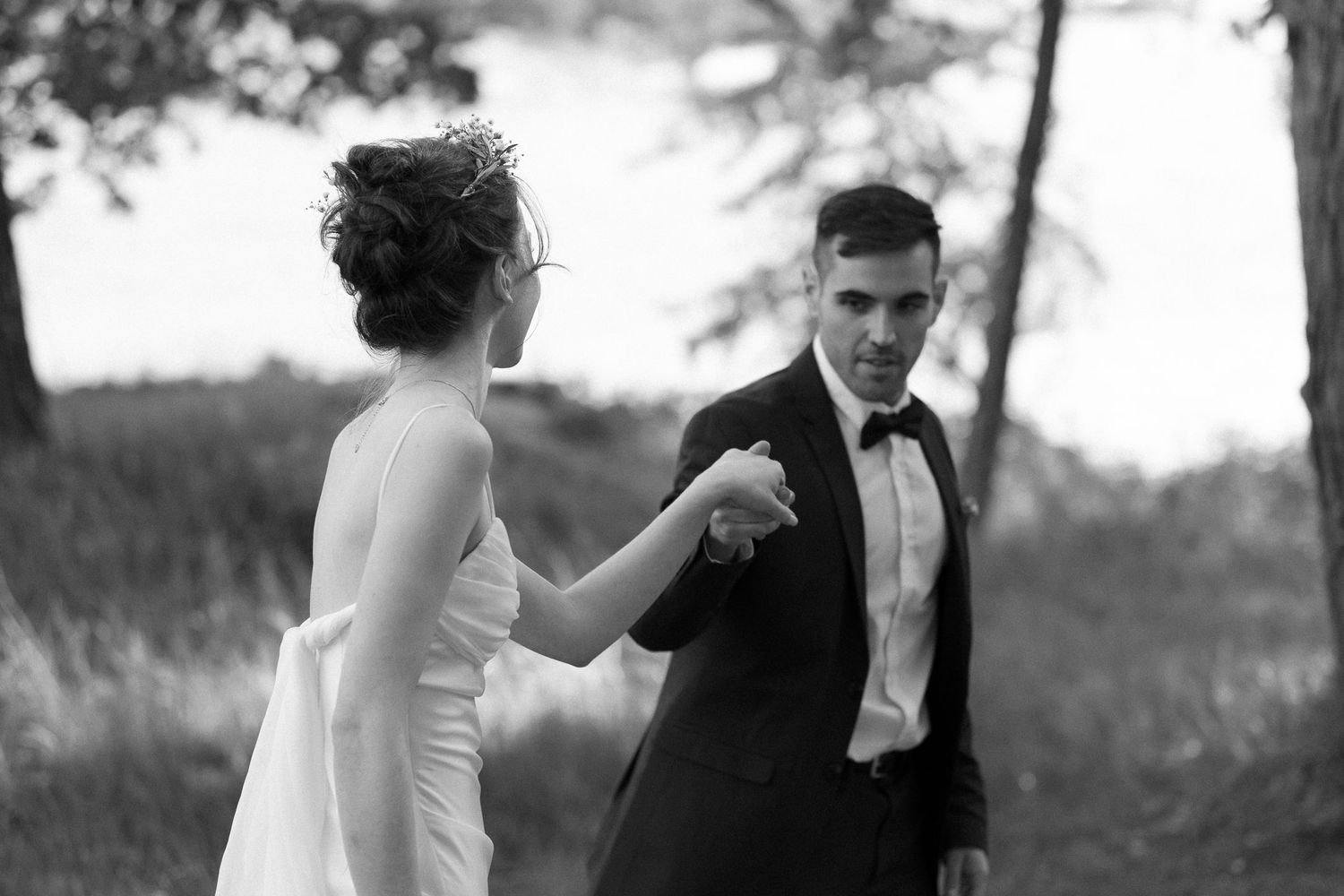 A black and white photo of a couple dancing outdoors during their wedding celebration.
