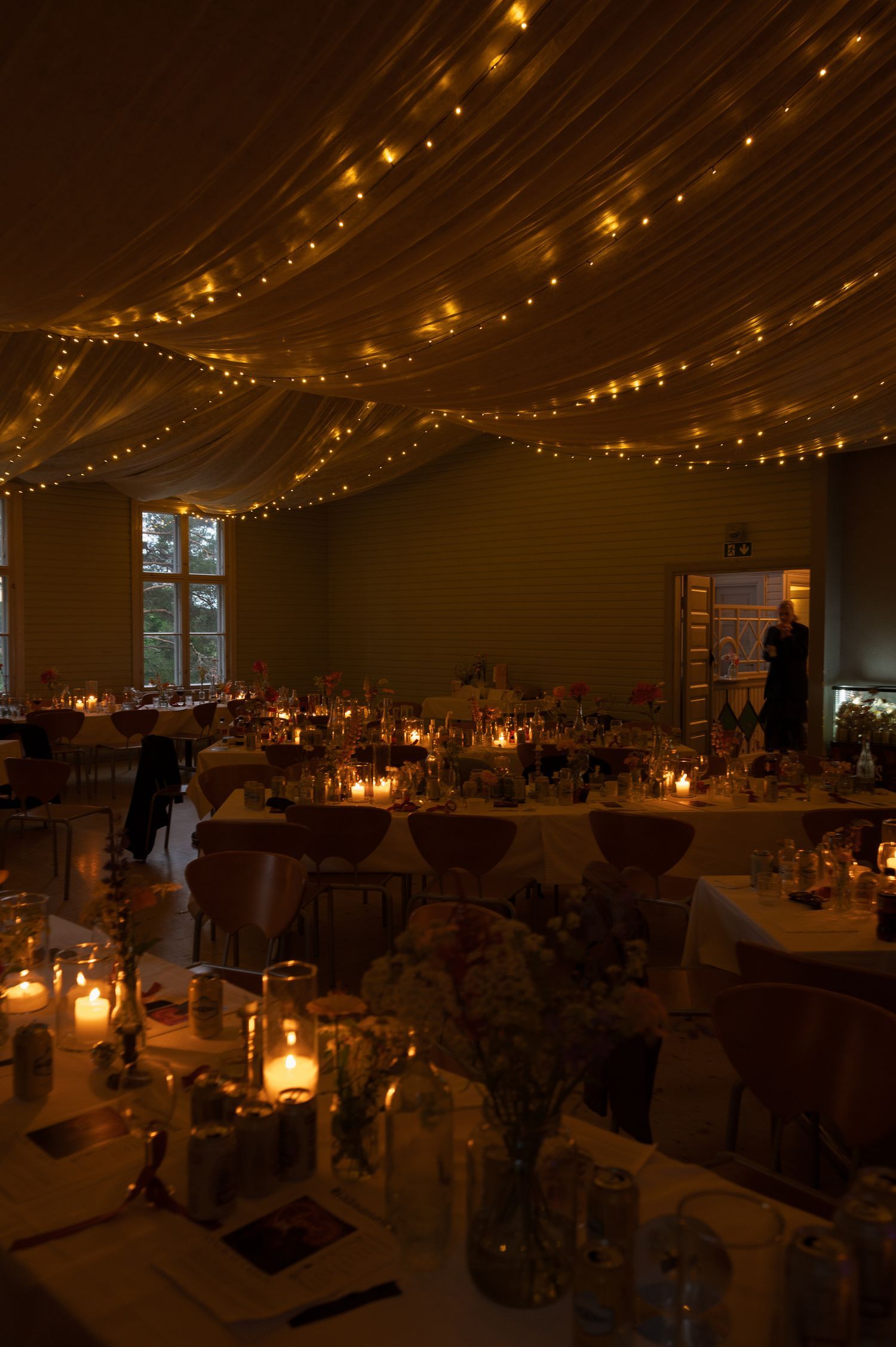 Reception venue decorated with warm string lights and candlelit tables creating romantic ambiance.