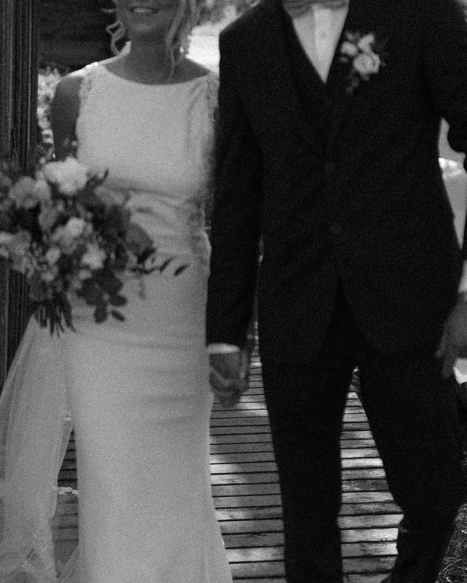 Wedding couple stands together in elegant black and white portrait series.