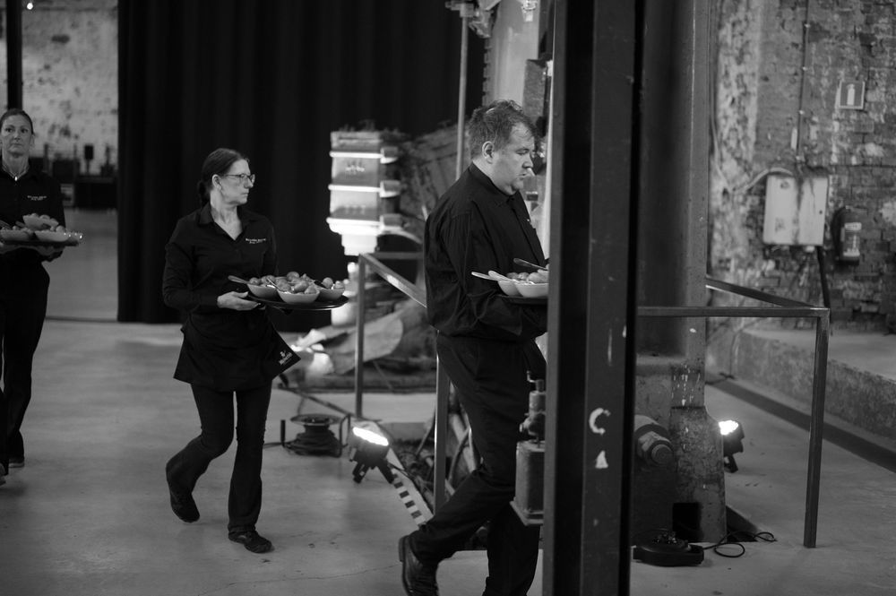 Black and white image of guests mingling in a modern urban venue.