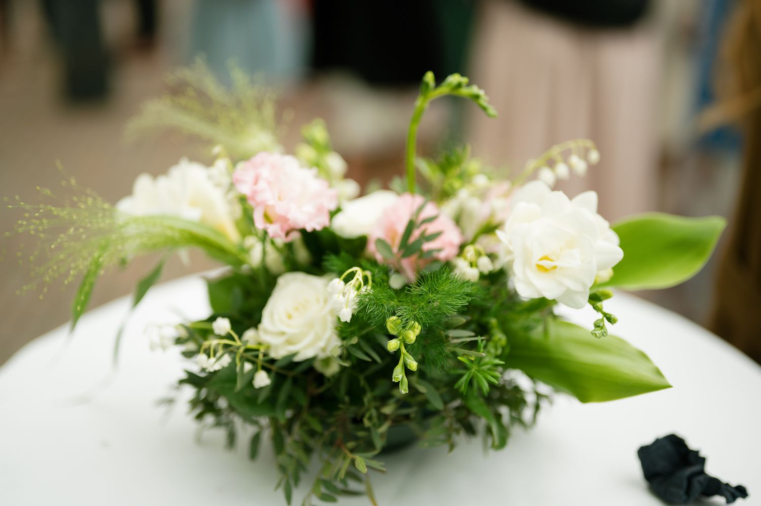 White floral arrangements with delicate blooms and greenery create an elegant wedding reception centerpiece display.