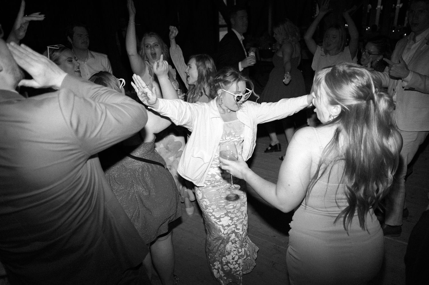 Black and white photo series showing dancers moving energetically at a lively party or dance event.