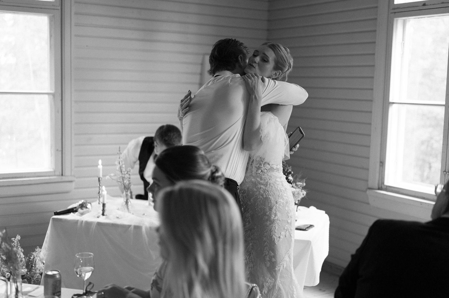 An emotional moment captured during a wedding reception beside a decorated table.
