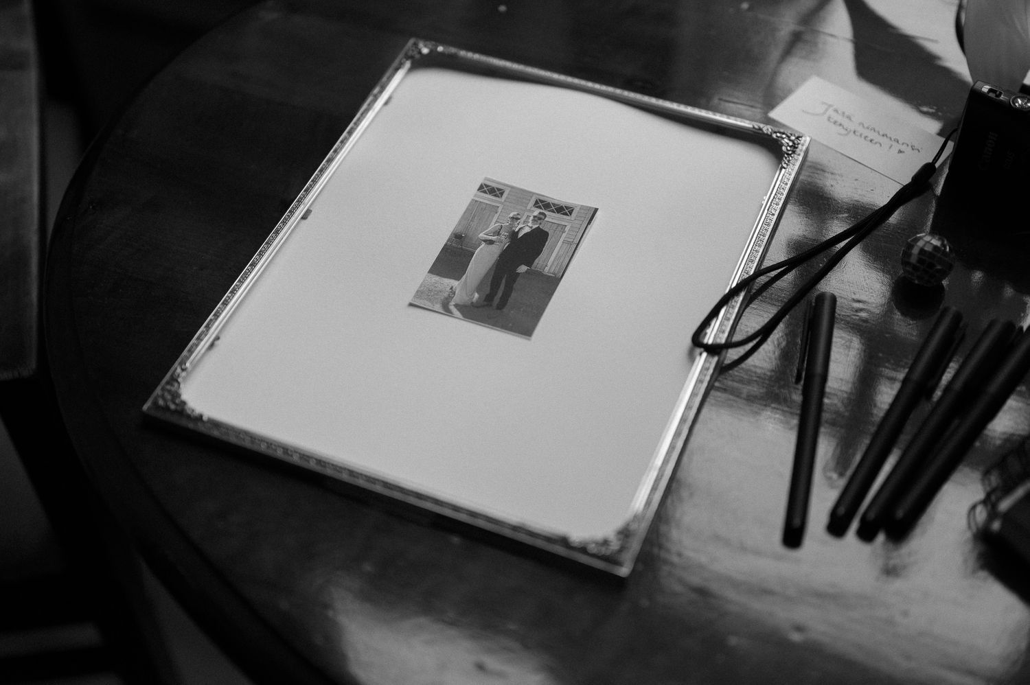 Black and white photo of an open photo album or guest book on a dark surface.