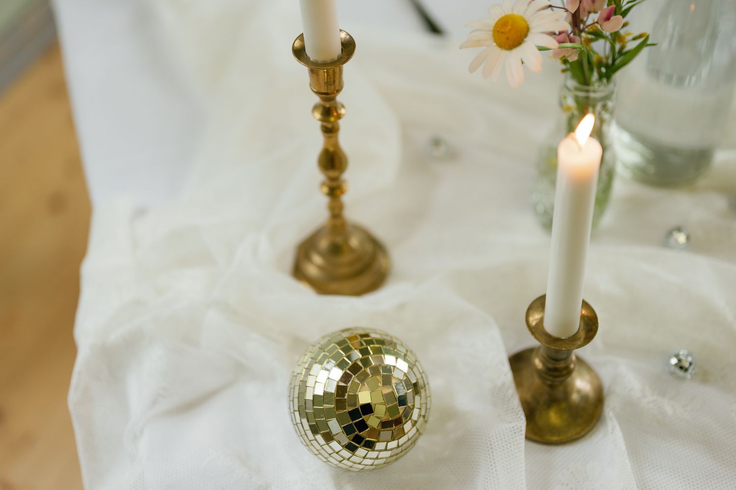 Elegant table setting with gold candlesticks and white linens.