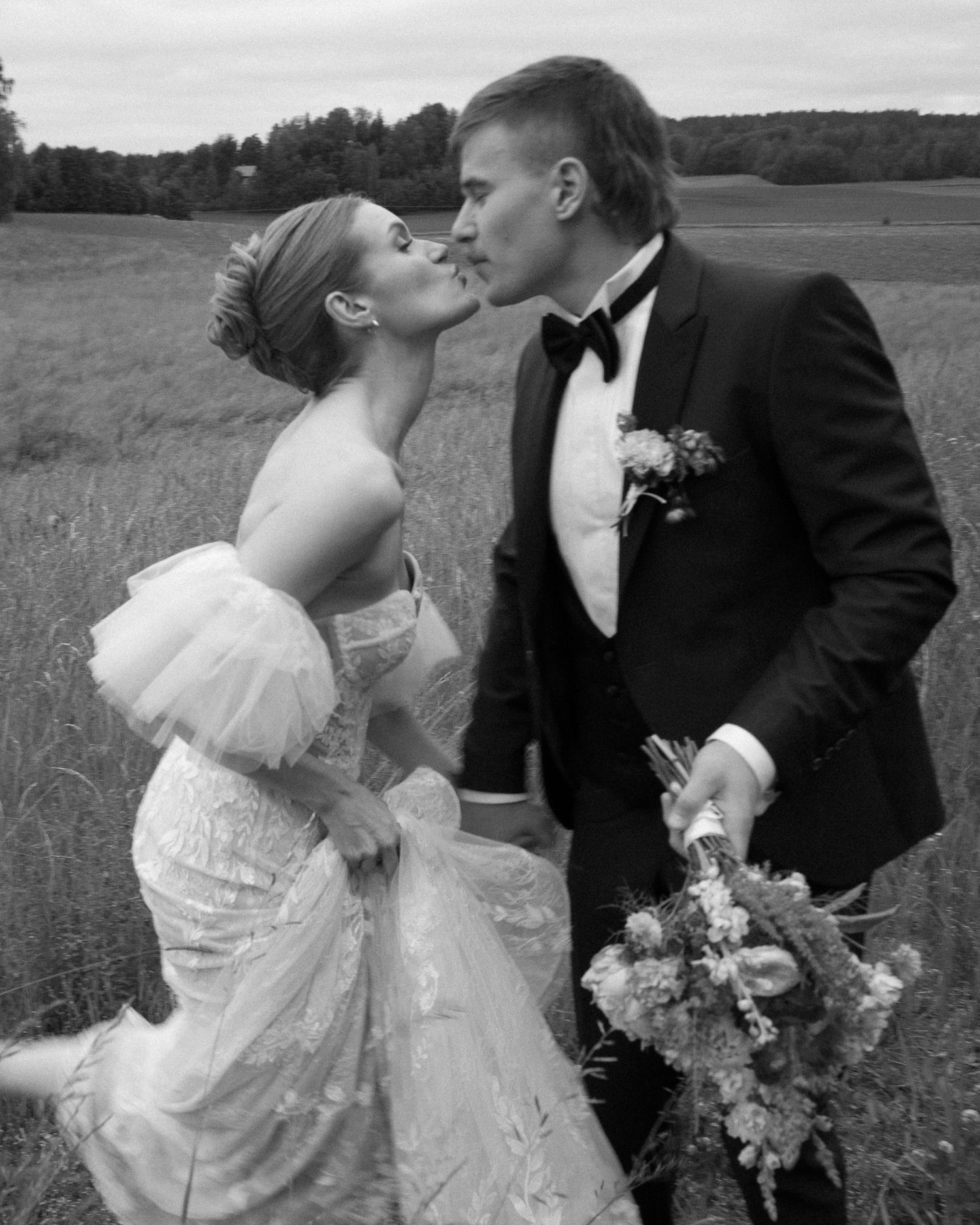 Wedding couple sharing romantic moments in a scenic field.
