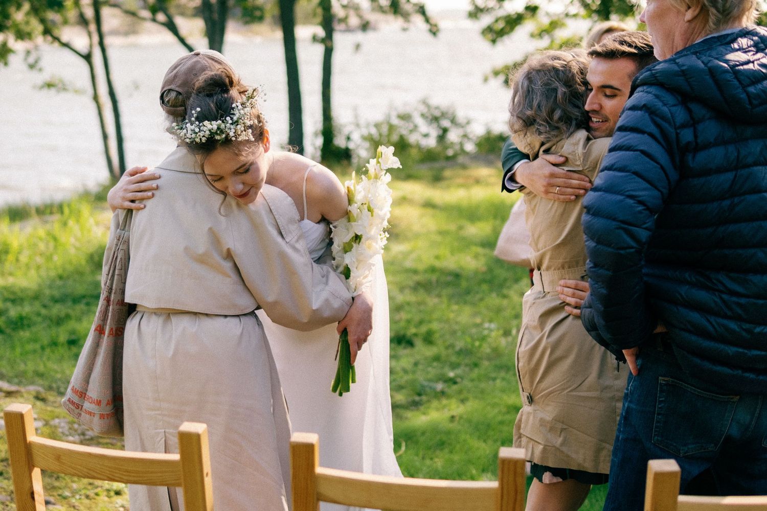 Wedding guests share warm embraces during an outdoor spring celebration.