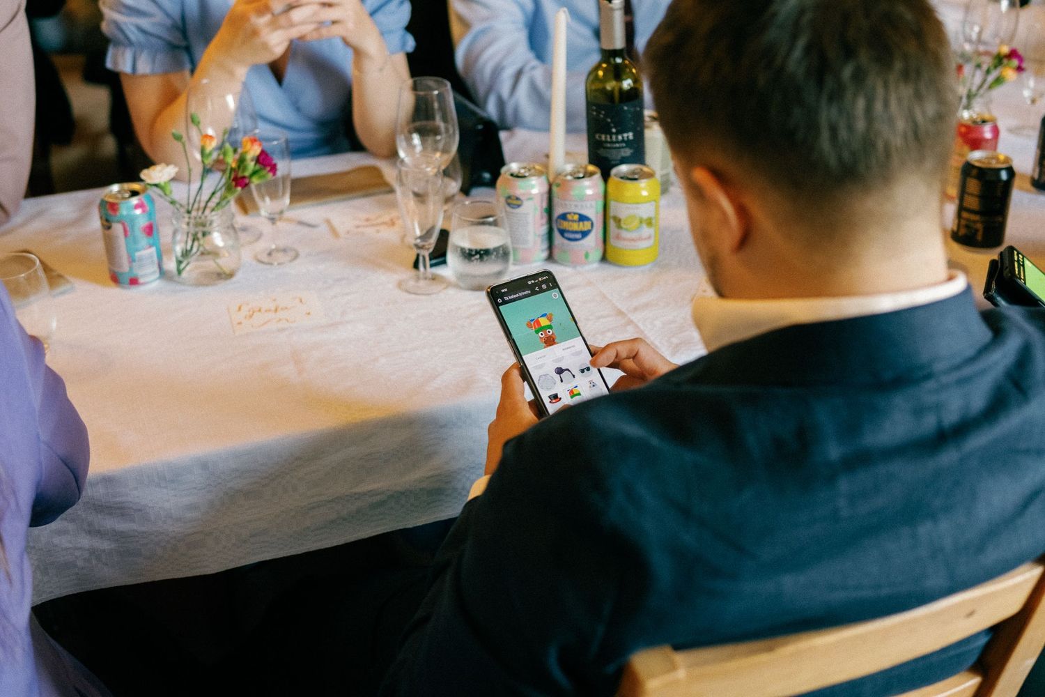 Wedding guests socializing at reception tables with drinks and decorations.