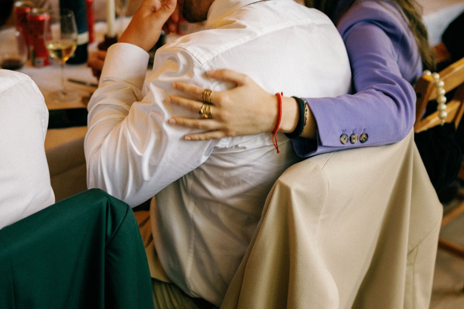 Guests in formal attire mingling at a wedding reception with drinks in hand.